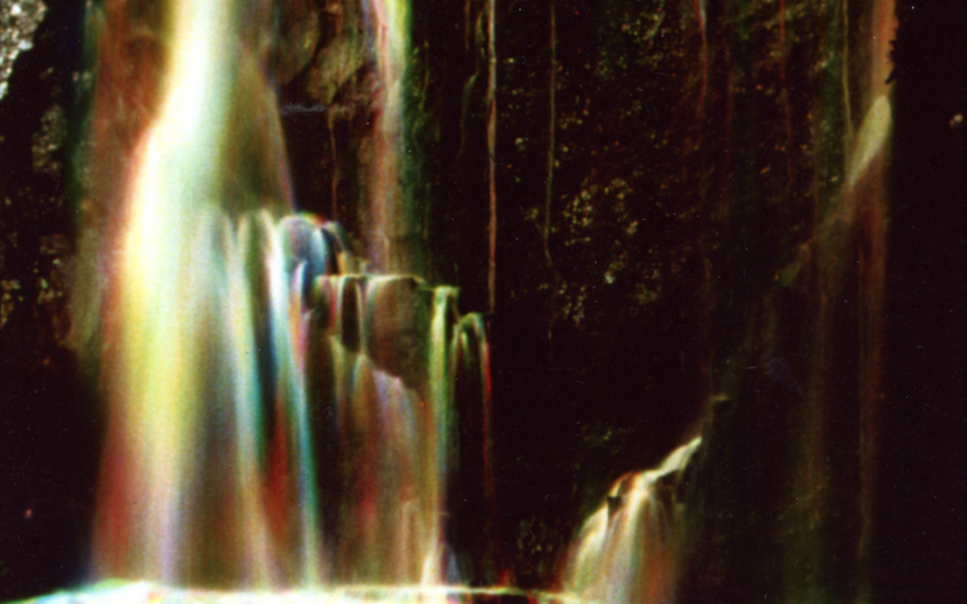 Film still from WATERFALL: A waterfall that sparkles in various colors.