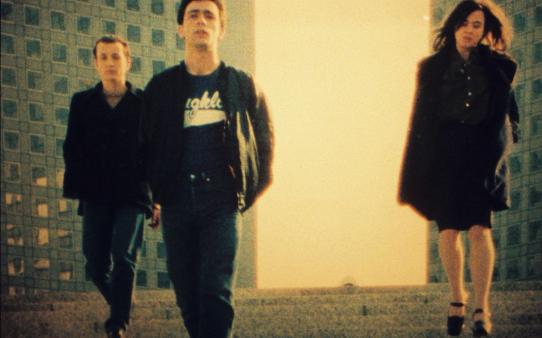 Film still from PETIT VOYAGE: Three young people between skyscrapers.