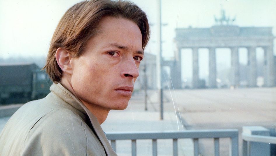 Filmstill aus DIE ARCHITEKTEN: Ein junger Mann mit nachdenklichem Gesichtsausdruck blickt zur Seite. Im Hintergrund ist das Brandenburger Tor zu sehen.