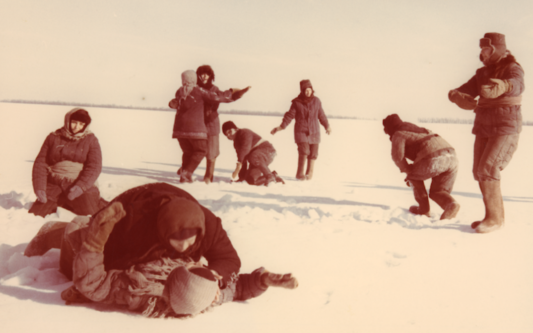 Film still from THE WALTZ ON THE PETSCHORA: A group of women are dancing in the snow, all dressed up.