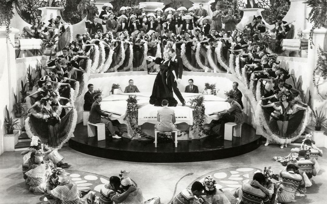 Film still from FLYING DOWN TO RIO. We see a mass dance scene, with Ginger Rogers and Fred Astaire in the center.