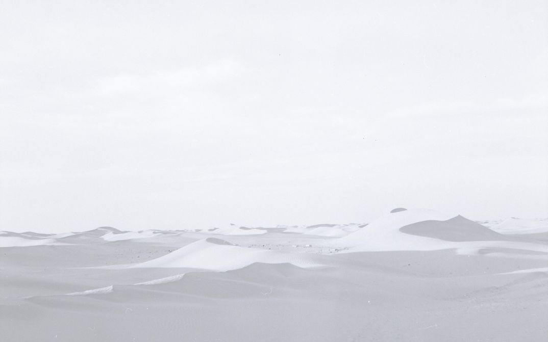 Film still from FATA MORGANA: A desert landscape in delicate black and white color tones.