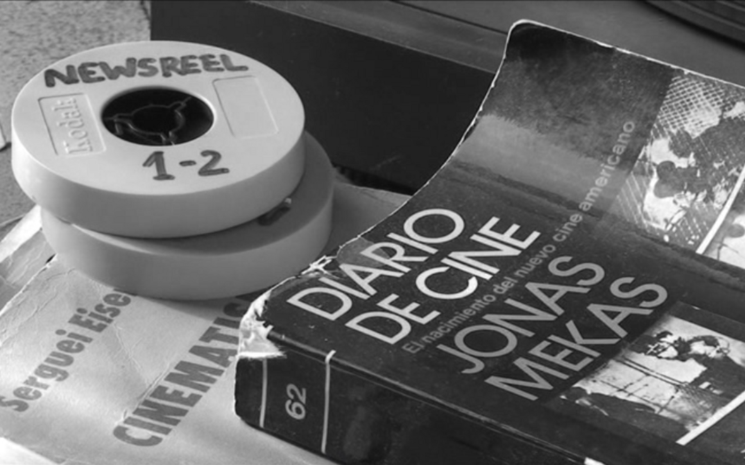 Film still from CORRESPONDENCIA JONAS MEKAS – J.L. GUERÍN: On a table are two Super 8 film reels and a book entitled "Diario de Cine. Jonas Mekas".