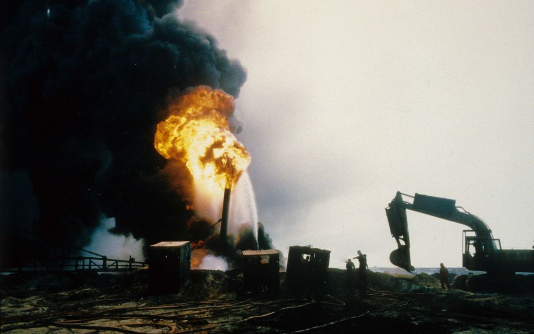 Film still from LEKTIONEN IN FINSTERNIS: You can see a burning oil well and thick, black smoke.