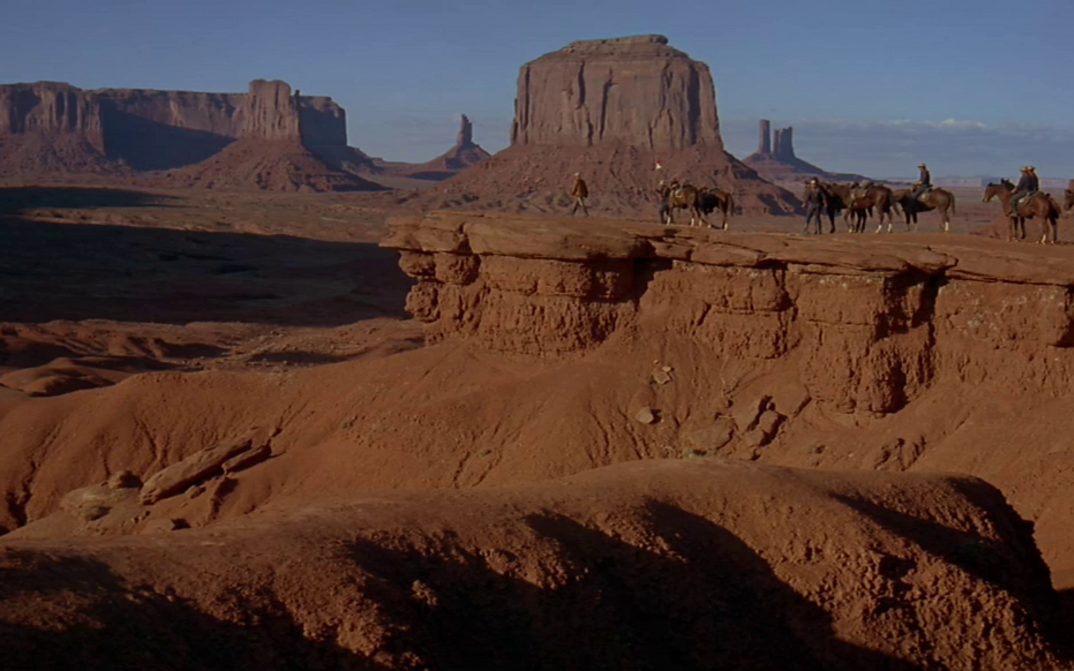 Film still from CHEYENNE AUTUMN: A group of horsemen in the desert of Monument Valley.