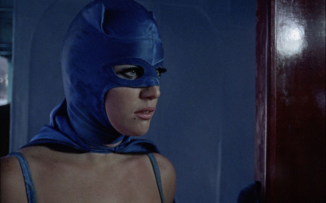 Film still from LA MUJER MURCIÉLAGO: Close-up of a woman in a purple superheroine costume.