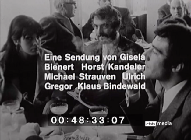 Film still from WIE JUNG IST DER JUNGE DEUTSCHE FILM: Several people are sitting in a restaurant. Above the picture the lettering of the television broadcast.