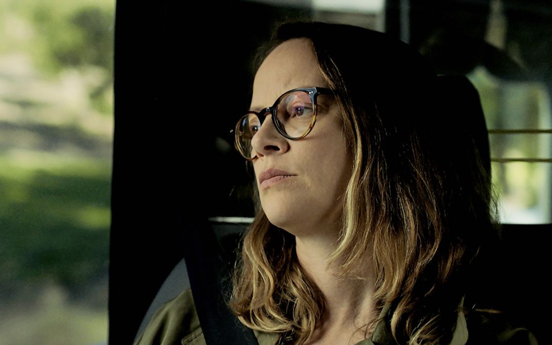 Filmstill from "Cidade Rabat" by Susana Nobre. A woman looks pensively out of the window of a car.