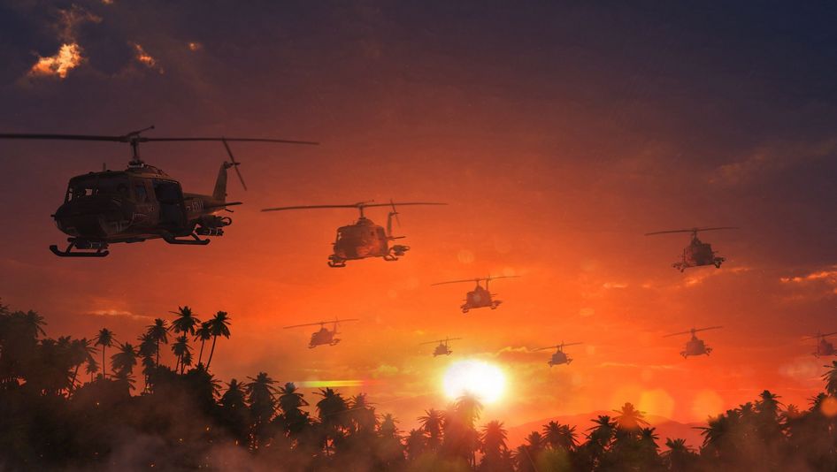 Film still from APOCALYPSE NOW: Several helicopters fly over palm trees in an orange sky.