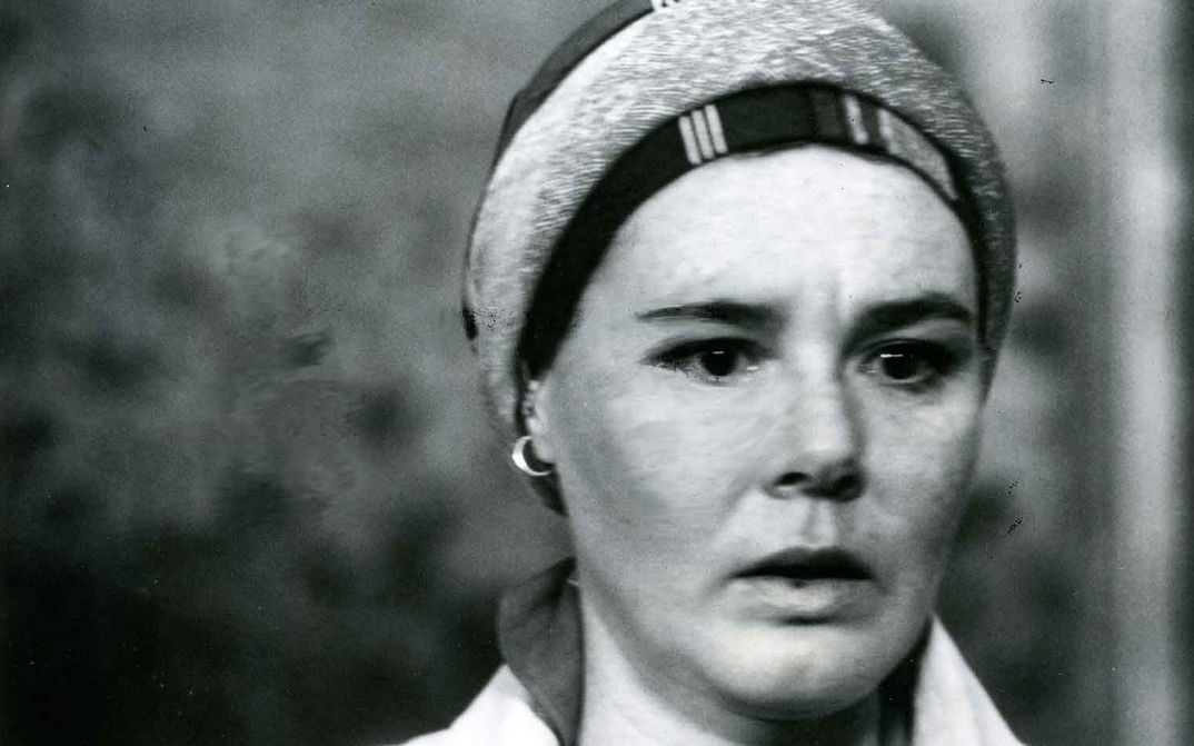 Film still from PILGRIM, FAREWELL: A woman looks into the camera.