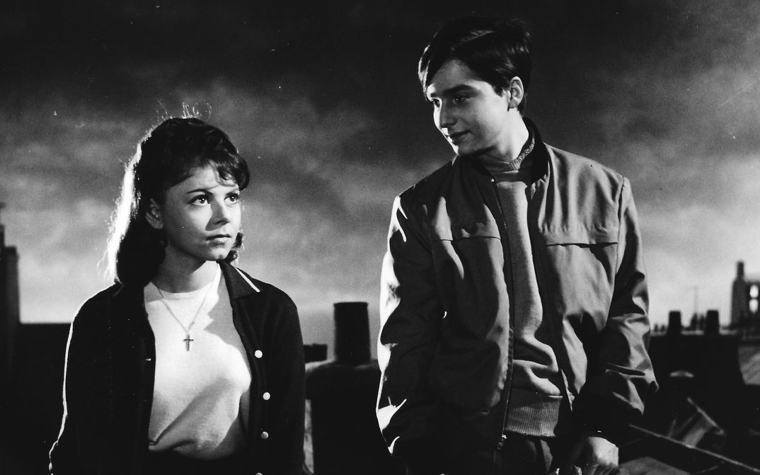 Film still from BOULEVARD: Two young people standing on a roof in Paris.