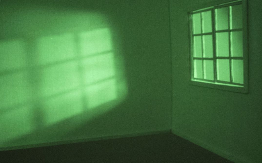 View of an empty room bathed in green light.