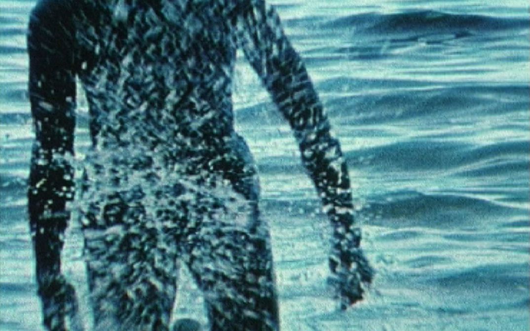 Film still from BABY I WILL MAKE YOU SWEAT: A person comes out of the sea.