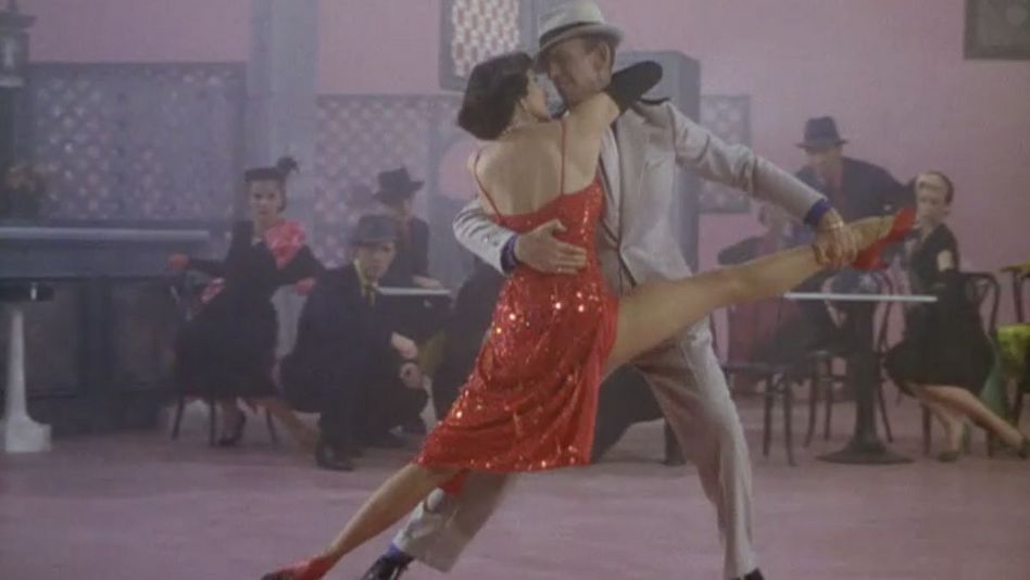 Filmstill aus THE BAND WAGON: Eine spektakuläre Tanzszene mit Cyd Charisse in einem glänzend-roten Kleid und Fred Astaire.