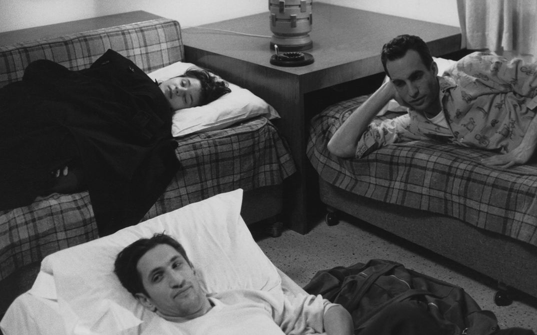 Film still from STRANGER THAN PARADISE: Two men and a woman lie in a room in improvised beds.
