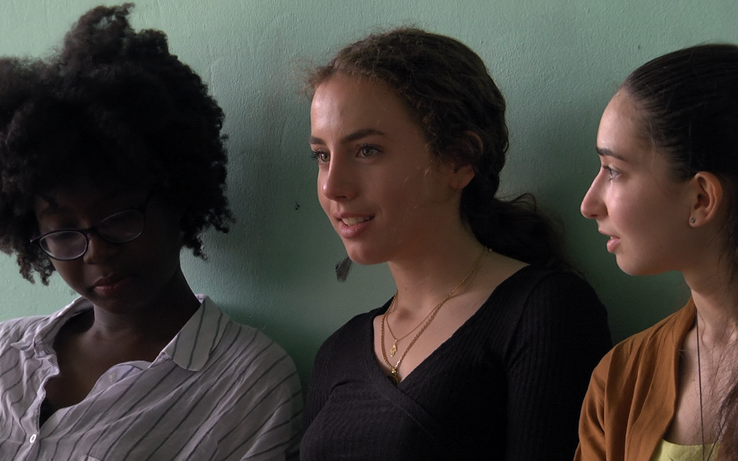 Film still from PREMIÈRES SOLITUDES: Three teenage girls in front of a green painted wall.