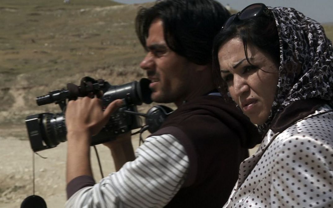 Film still from TRAUMFABRIK KABUL. A man and a woman with a film camera.