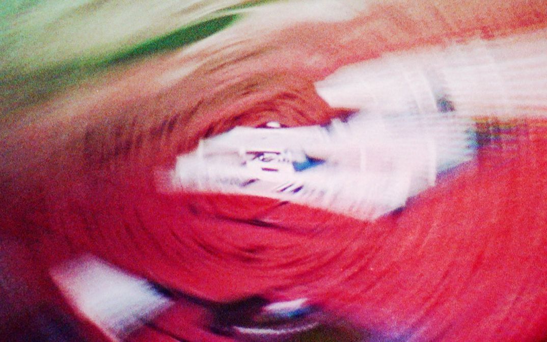 Still from the film "vs" by Lydia Nsiah. Abstract spiral in red and green. A house-like structure can also be seen.