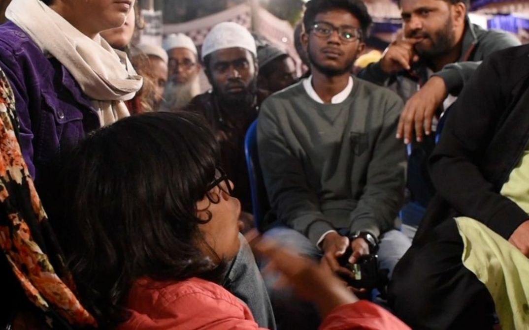 Still from the film "All Was Good" by Teresa A Braggs. People sit close together and talk animatedly.