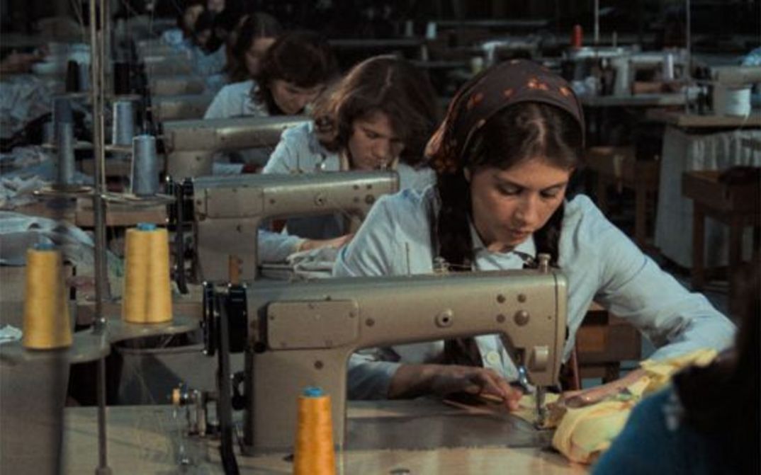 Film still from KARA KAFA: A row of sewing machines with seamstresses.
