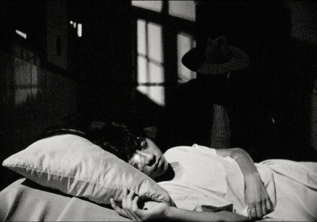 Filmstill aus PUNKU von J.D. Fernández Molero. Das Schwarz-Weiß-Bild zeigt eine Nahaufnahme einer schlafenden Person in einem Bett.