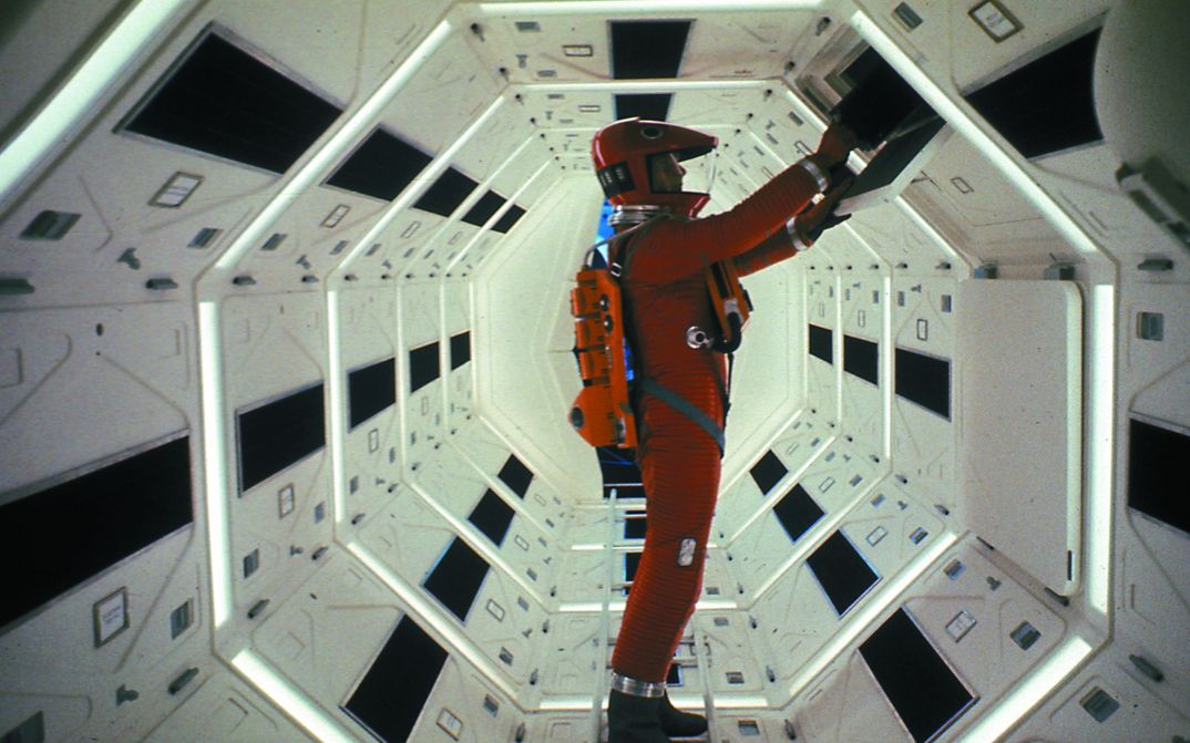 Film still from 2001: An astronaut in a red spacesuit at a switching element.