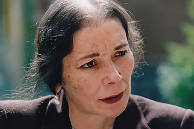 A portrait of the activist and filmmaker Melanie Spitta. She is speaking while looking past the camera to the right.