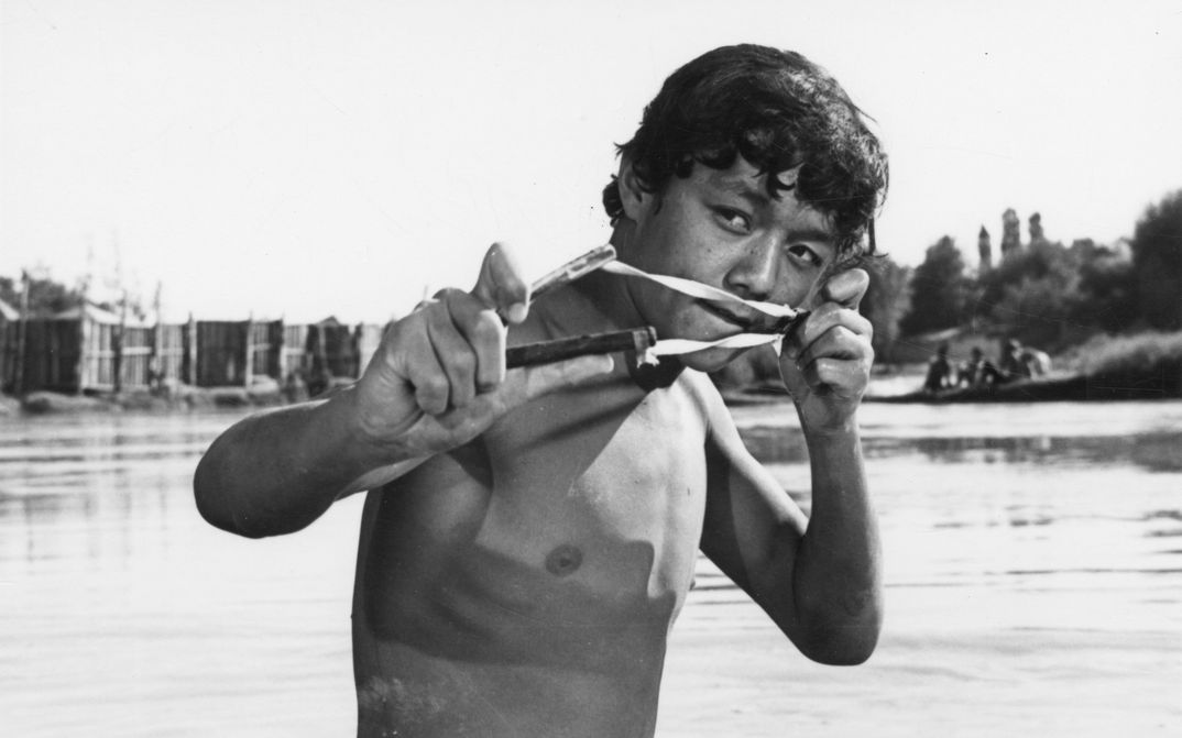 Filmstill from NEZHNOST (Zärtlichkeit). Ein Jugendlicher mit einer Steinschleuder in der Hand.