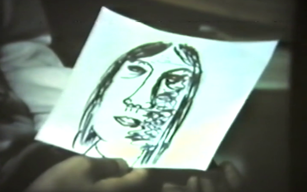 Film still from FRAUEN IN BERLIN: A hand holds a drawing of a woman