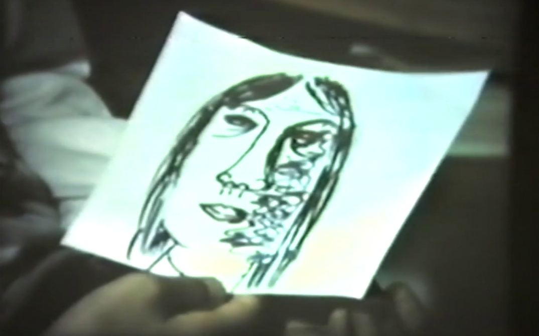 Film still from FRAUEN IN BERLIN: A hand holds a drawing of a woman