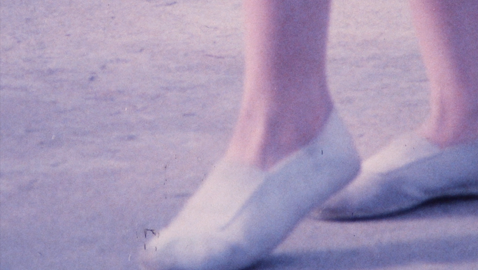 Film still from VIA DOLOROSA: You can see a pair of feet in gym shoes.