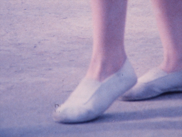 Film still from VIA DOLOROSA: You can see a pair of feet in gym shoes.