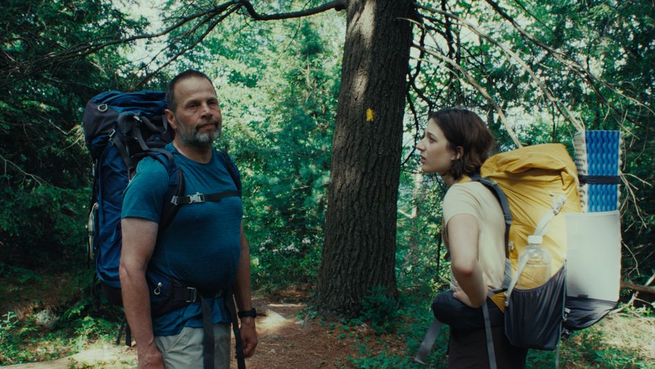 Filmstill aus GOOD ONE: Eine Teenagerin und ihr Vater stehen mit großen Wanderrucksäcken im Wald.