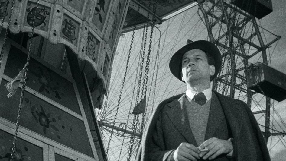 Film still from THE THIRD MAN: A man stands in front of a Ferris wheel.