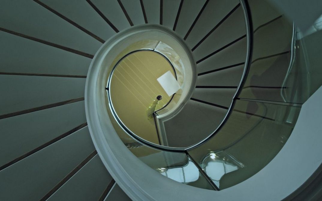 Still from the film "Voices and Shells" by Maya Schweizer. A spiral staircase from above.