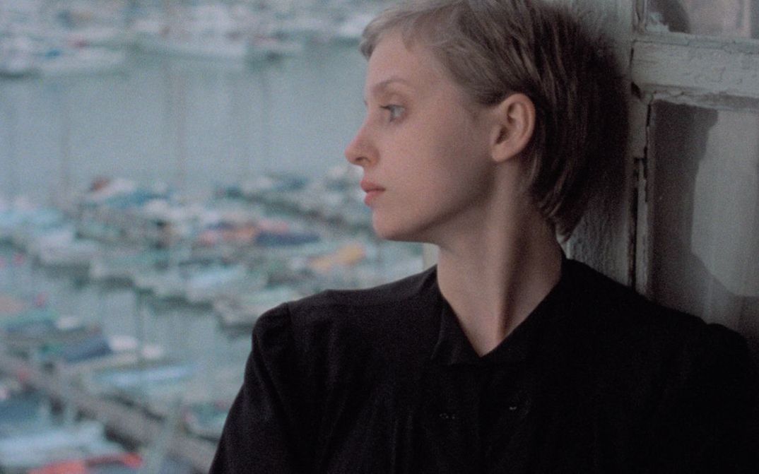 Film still from FLUCHTWEG NACH MARSEILLE. The profile of Katharina Thalbach, in the background the old port of Marseille.